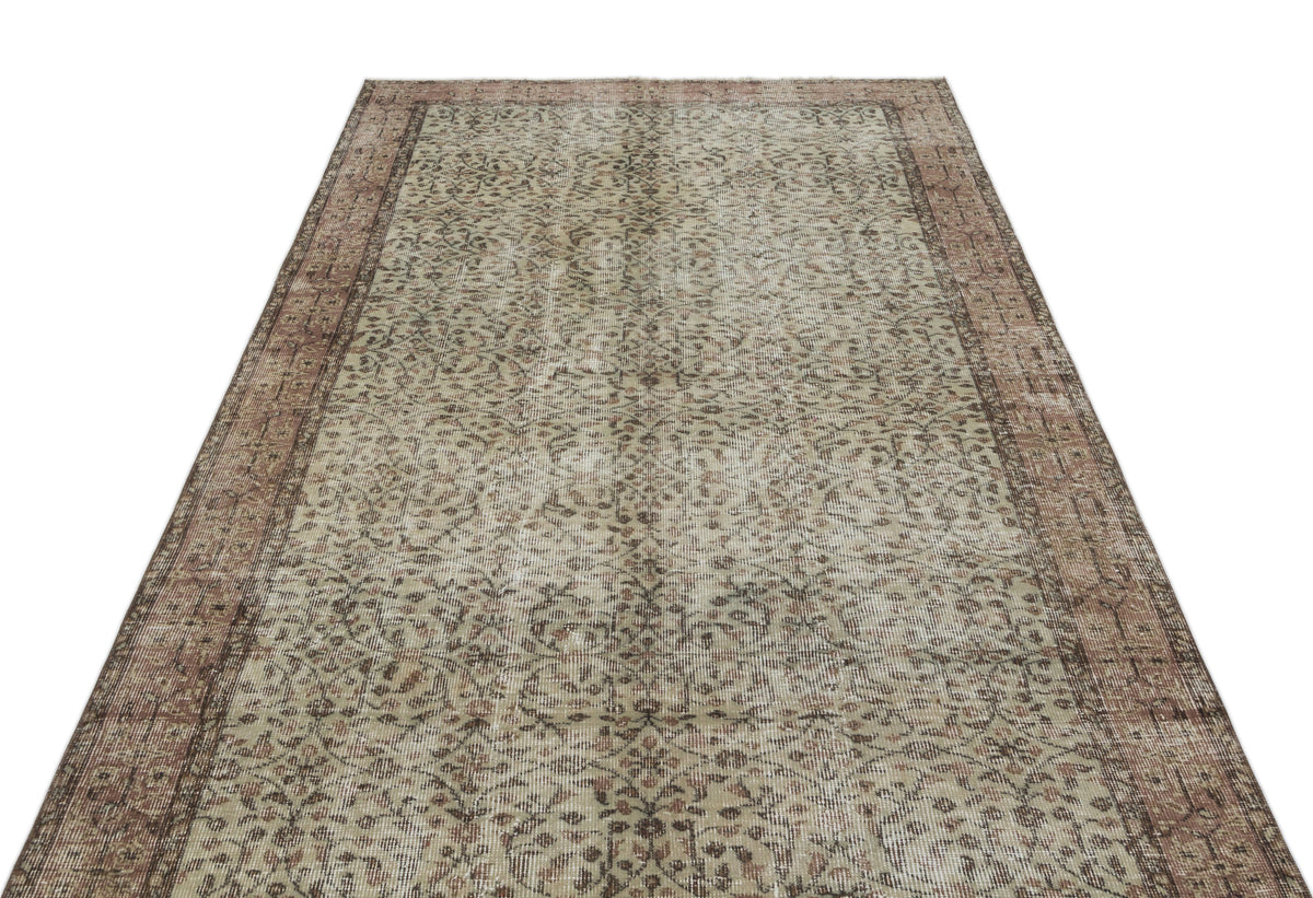 Distressed beige and brown vintage-style rug with an intricate floral pattern and a wide decorative border.