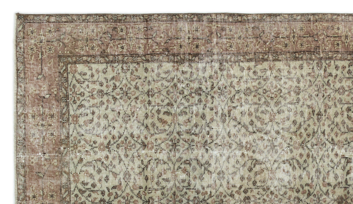 Distressed beige and brown rug with a traditional floral vine pattern and a wide decorative border.