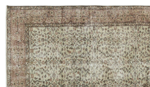Load image 1 in gallery view. Distressed beige and brown rug with a traditional floral vine pattern and a wide decorative border.