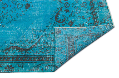 Load image 1 in gallery view. Bright turquoise rug with a distressed charcoal grey traditional medallion pattern, shown with a corner folded over.