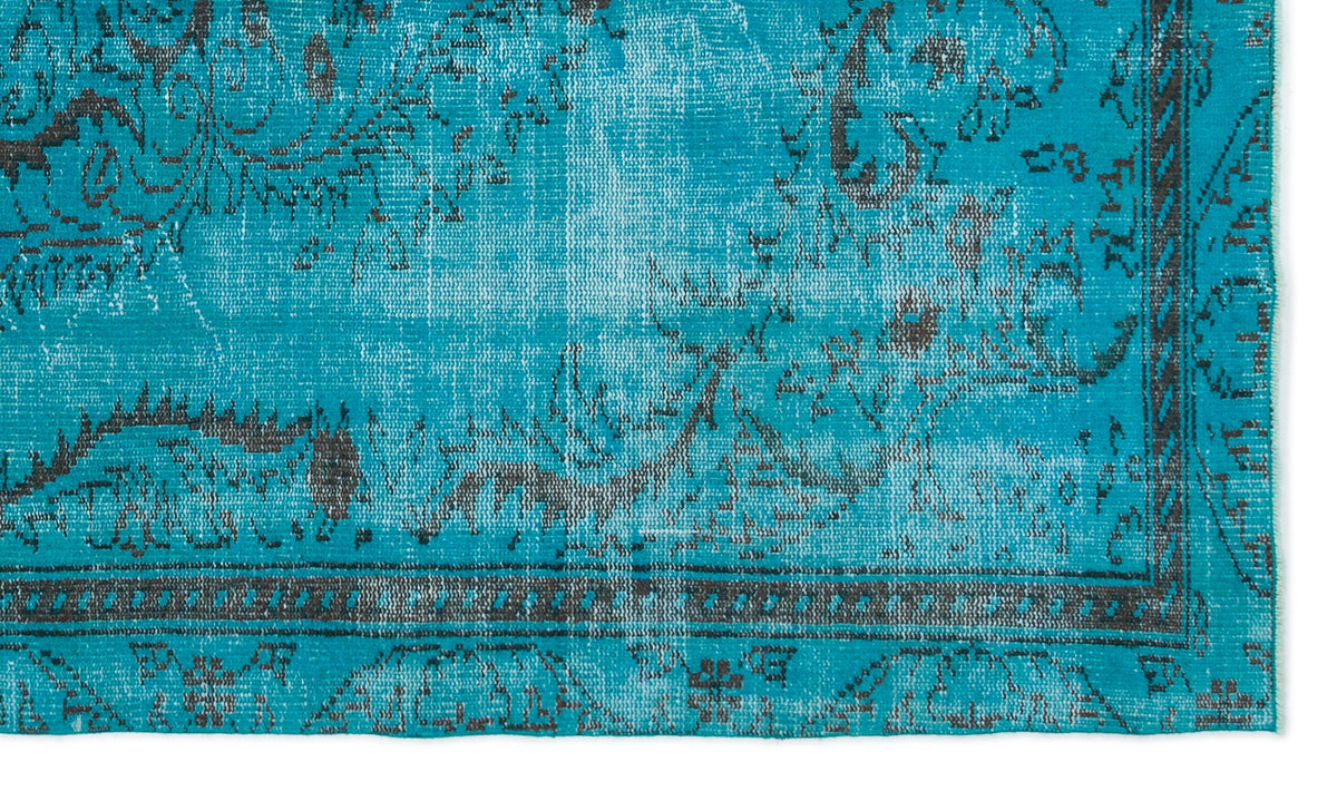 Bright turquoise rug with a distressed charcoal grey traditional floral pattern and a geometric border.