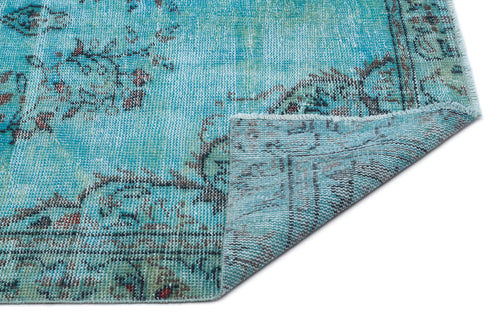 Load image 1 in gallery view. Distressed turquoise rug with a faded floral medallion pattern and a folded corner showing the woven backing.