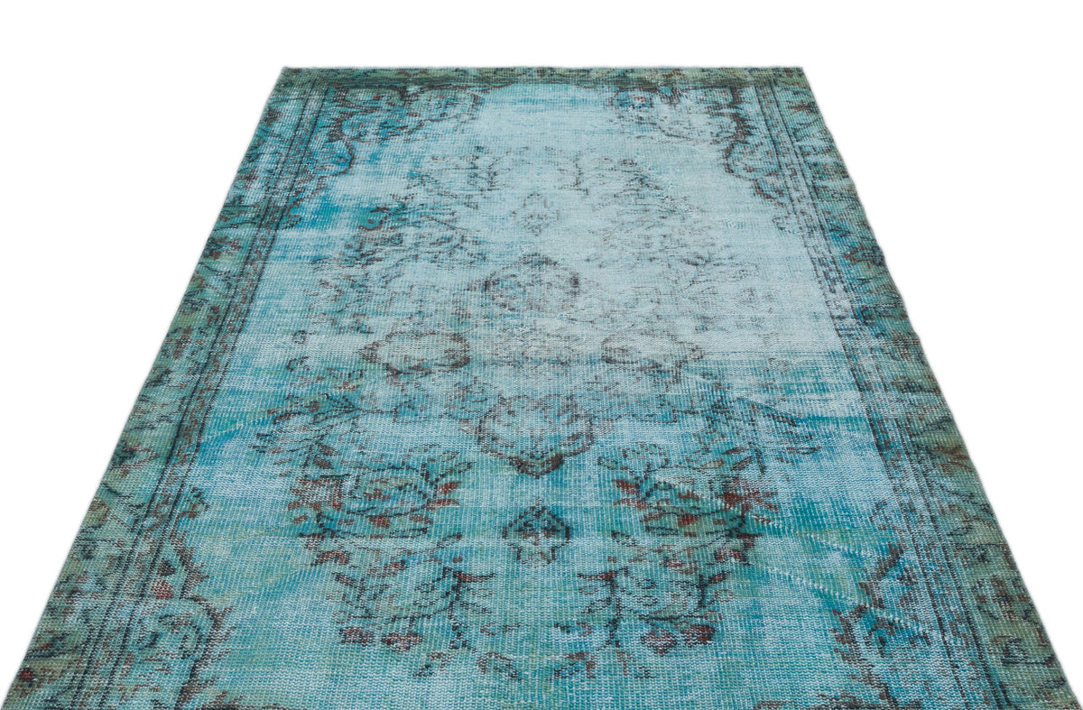 Distressed turquoise and teal area rug with a faded traditional medallion pattern and dark border on a white background.