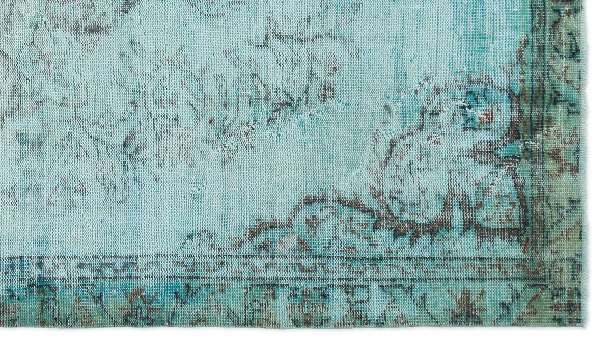 Distressed turquoise and teal rug with a faded dark brown traditional floral medallion pattern.