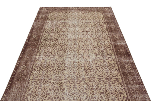 Load image 1 in gallery view. Brown and beige vintage-style rug with a distressed floral medallion pattern and a wide decorative border.