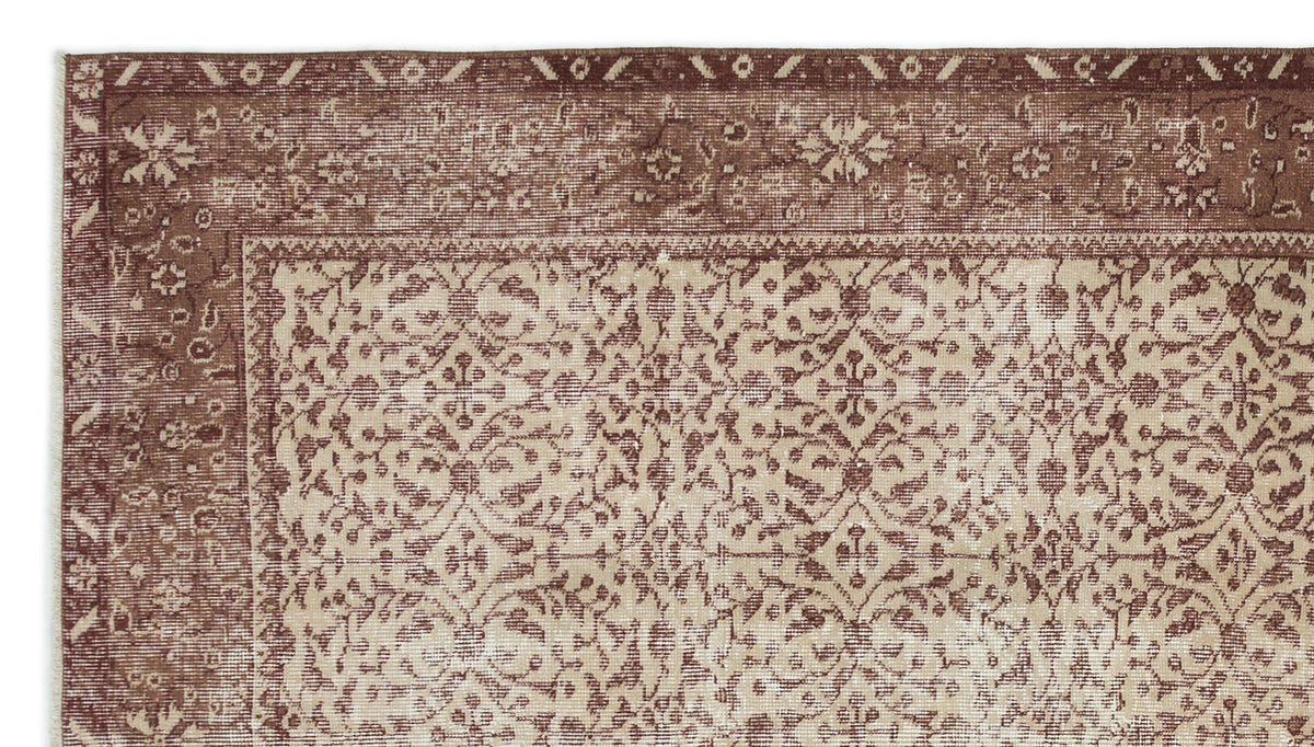 Brown and beige rug with a distressed traditional floral medallion pattern and a wide decorative border.