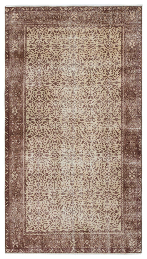 Load image 1 in gallery view. Brown and beige vintage-style rug with a distressed floral vine pattern and a wide decorative border.