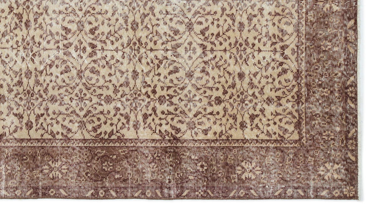 Beige and brown distressed rug with a traditional floral medallion pattern and a wide decorative border.
