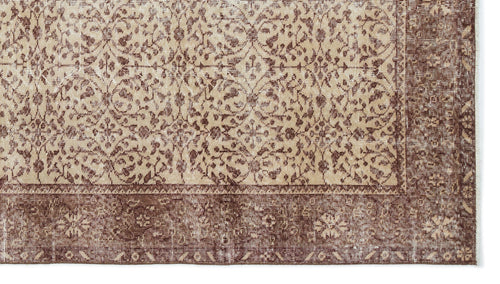 Load image 1 in gallery view. Beige and brown distressed rug with a traditional floral medallion pattern and a wide decorative border.