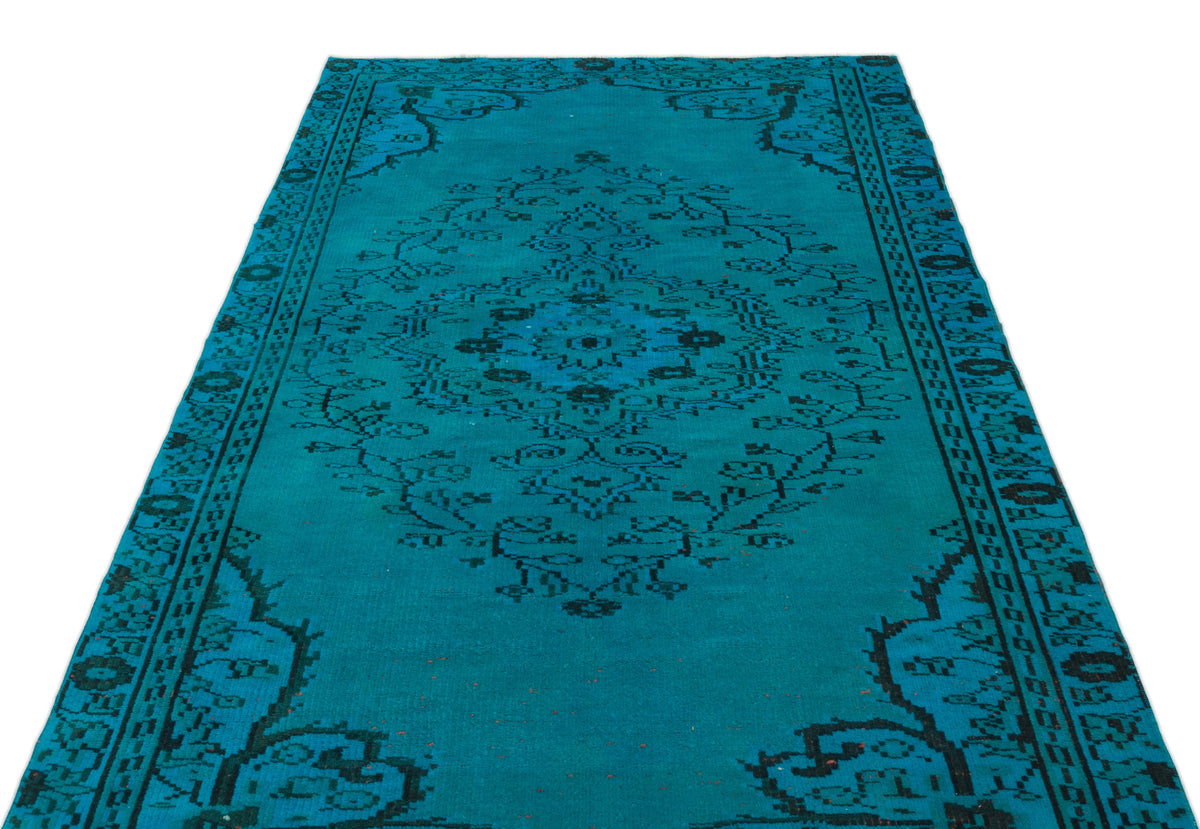 Teal rug with a black traditional floral medallion pattern and ornate border on a white background.