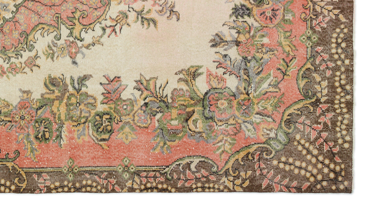 Cream rug with a floral medallion pattern in coral, green, and brown, featuring a dark brown border.