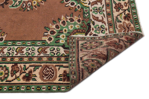 Load image 1 in gallery view. Brown traditional rug with green and cream floral border patterns, shown with a folded corner on a white background.