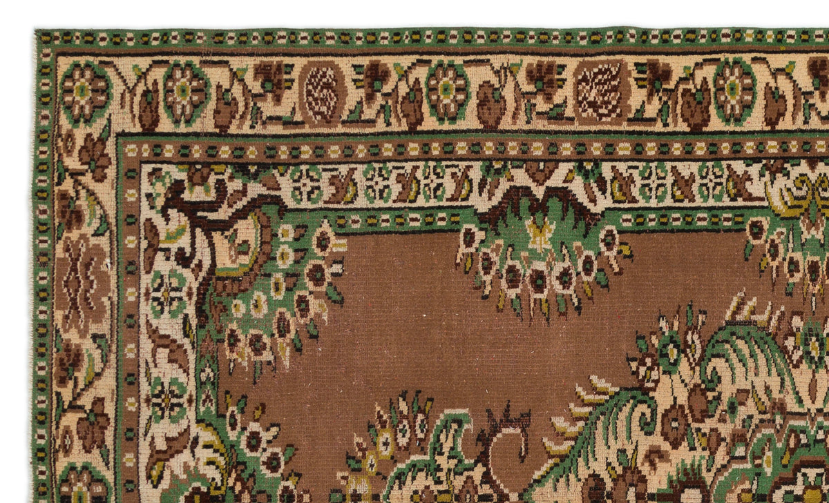 Brown, green, and cream traditional rug with a floral border and central medallion pattern.