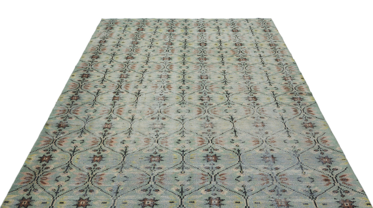 Light blue area rug with a repeating dark grey diamond lattice pattern and muted floral accents.