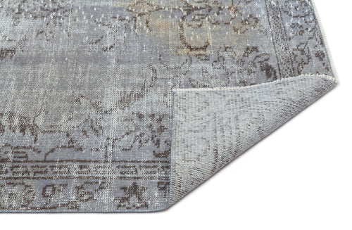 Load image 1 in gallery view. Grey and charcoal distressed traditional rug with a floral medallion pattern, shown with a corner folded over.