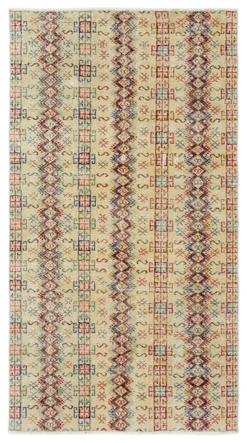 Load image 1 in gallery view. Beige rug with vertical stripes of geometric diamonds and repeating tribal motifs in red, blue, and green.