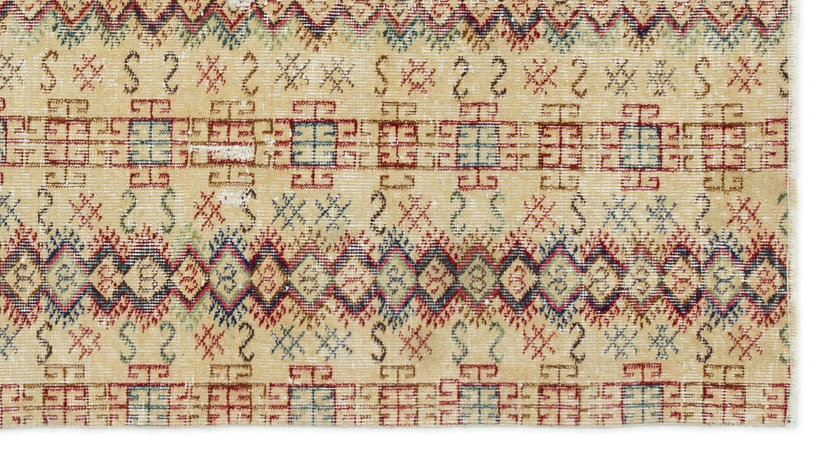Beige rug with a distressed tribal pattern featuring red, blue, and green geometric diamonds and linear motifs.
