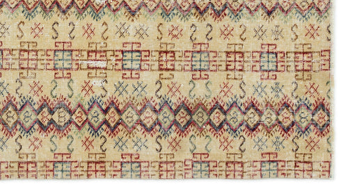 Load image 1 in gallery view. Beige rug with a distressed tribal pattern featuring red, blue, and green geometric diamonds and linear motifs.