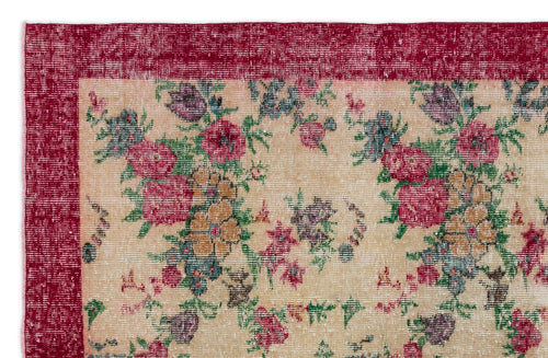 Load image 1 in gallery view. Distressed beige rug with a deep red border and a multi-colored floral pattern in pink, green, and purple.
