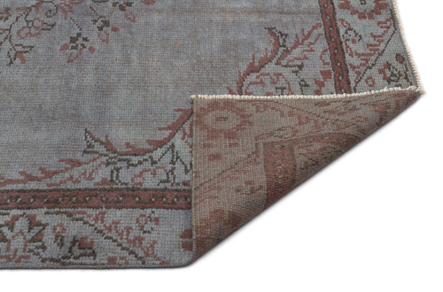 Load image 1 in gallery view. Blue-grey and terracotta vintage-style rug with a floral medallion pattern, shown with a corner folded over.