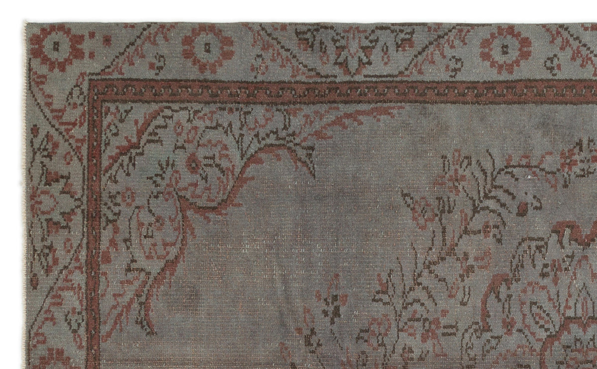 Grey and terracotta traditional rug with a distressed floral border and corner motif on a white background.