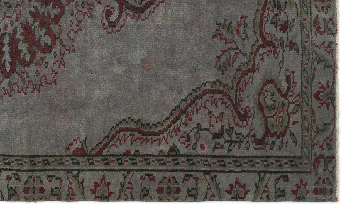 Grey distressed rug with a red and olive green traditional floral border and medallion pattern.