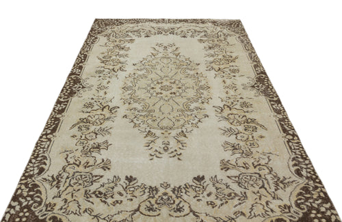 Load image 1 in gallery view. Beige and brown vintage-style rug with a central floral medallion and ornate border on a white background.