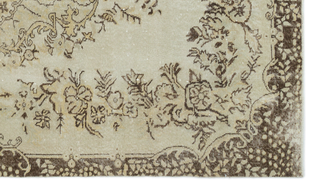 Beige and brown distressed rug with a traditional floral medallion pattern and ornate border.