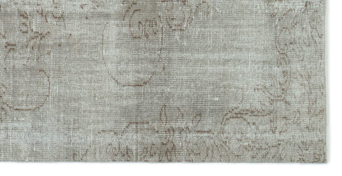 Taupe and grey rug with a faded, distressed traditional floral medallion pattern.