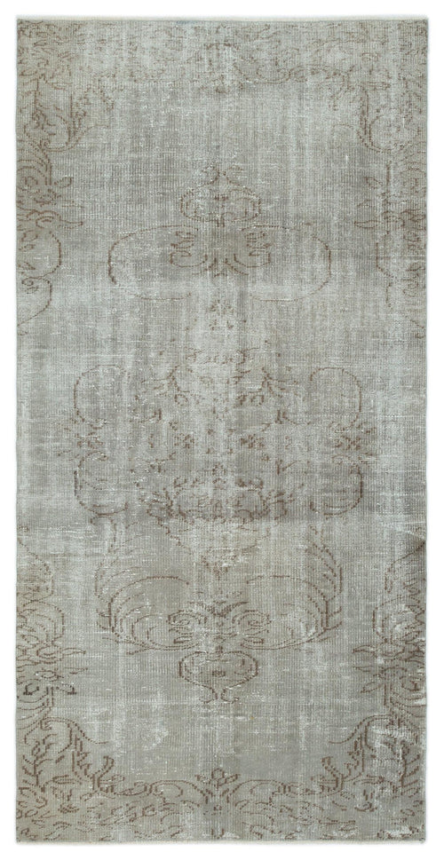 Load image 1 in gallery view. Grey and taupe distressed rug with a faded central floral medallion pattern on a white background.