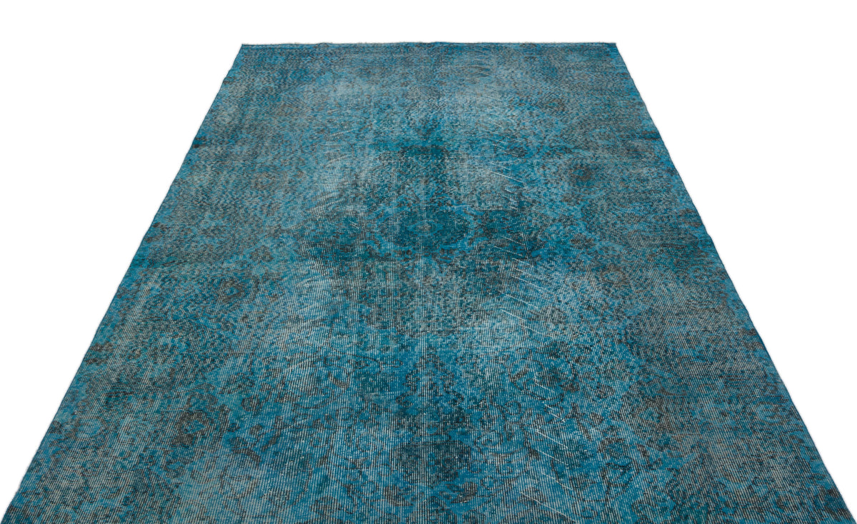 Teal and charcoal distressed rug with a faded traditional medallion pattern on a white background.