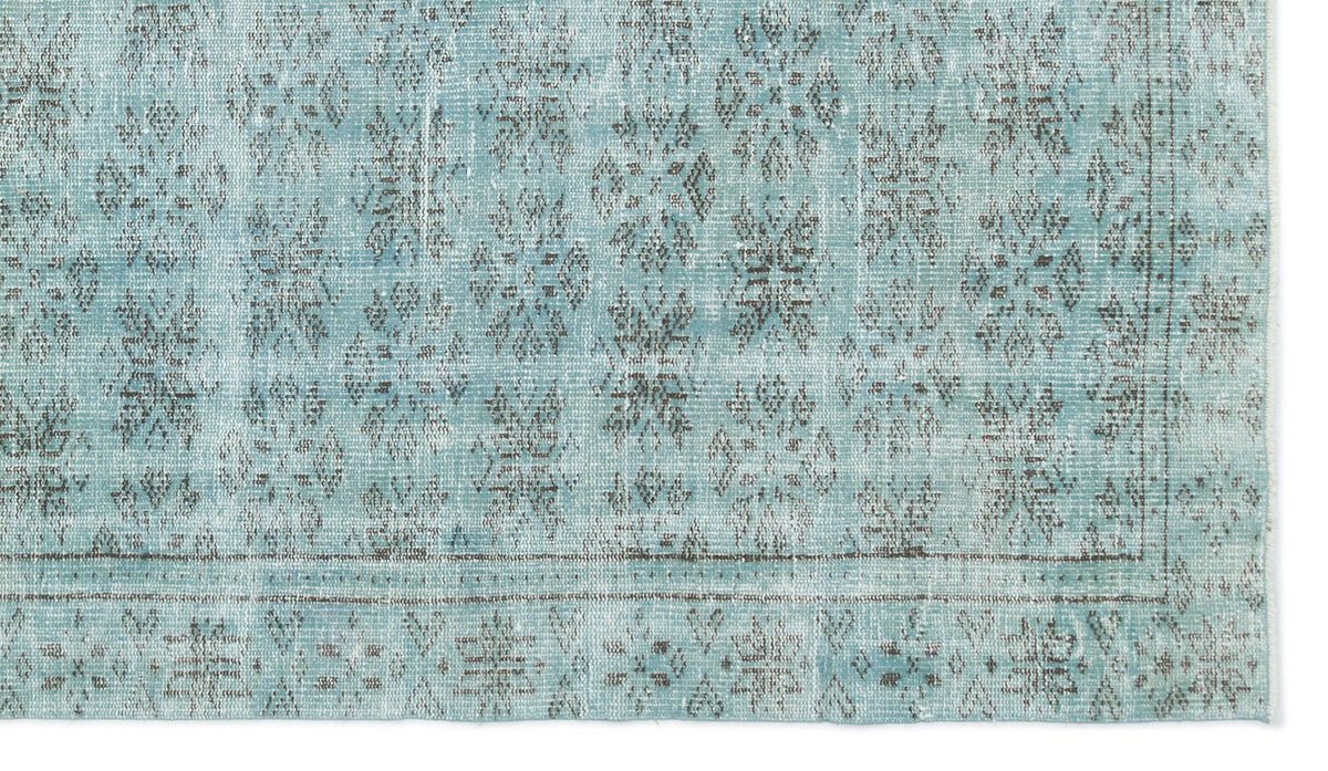 Light blue distressed rug with a dark grey repeating floral medallion pattern and a bordered edge.