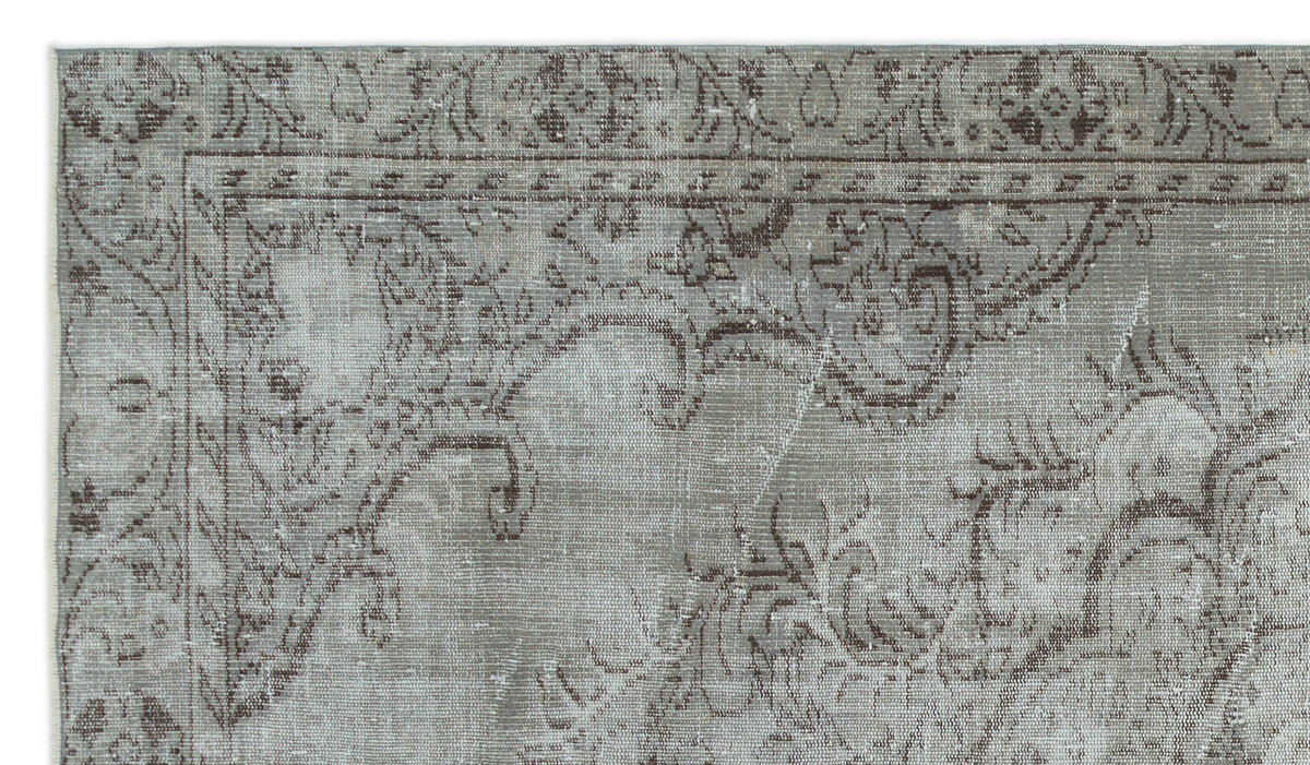 Grey and brown distressed rug with a traditional ornate floral border and medallion pattern.