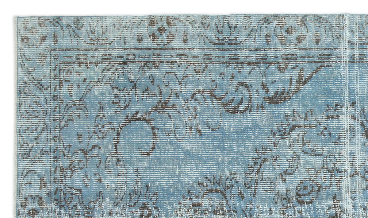 Light blue and charcoal grey rug with a distressed, traditional floral medallion pattern.