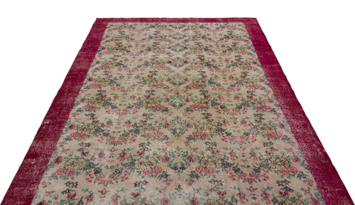 Load image 1 in gallery view. Beige vintage-style rug with a floral pattern and a wide, distressed magenta border on a white background.