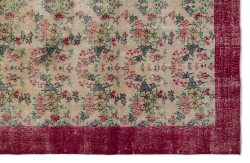 Load image 1 in gallery view. Beige rug with a distressed floral pattern in red, yellow, and purple, featuring a solid deep red border.