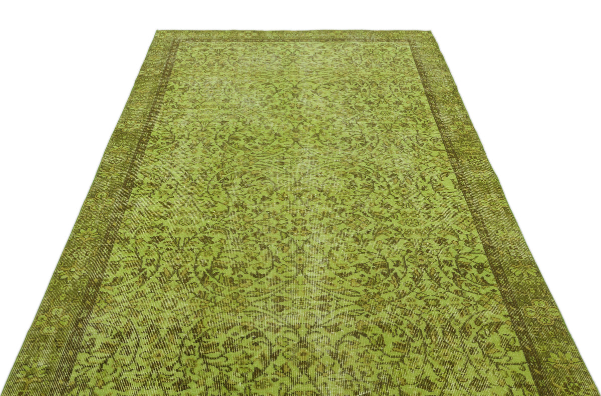 Chartreuse and olive green vintage-style rug with a distressed floral medallion pattern and a wide border.