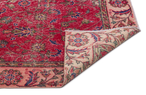 Load image 1 in gallery view. Red and beige traditional rug with a floral medallion pattern and a folded corner, isolated on a white background.