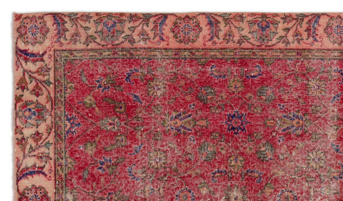 Red and peach traditional rug with a floral vine pattern and a wide decorative border.