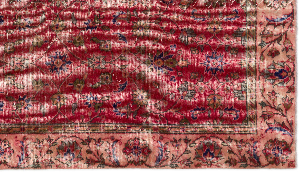 Red and pink traditional rug with a distressed floral medallion pattern and a detailed botanical border.