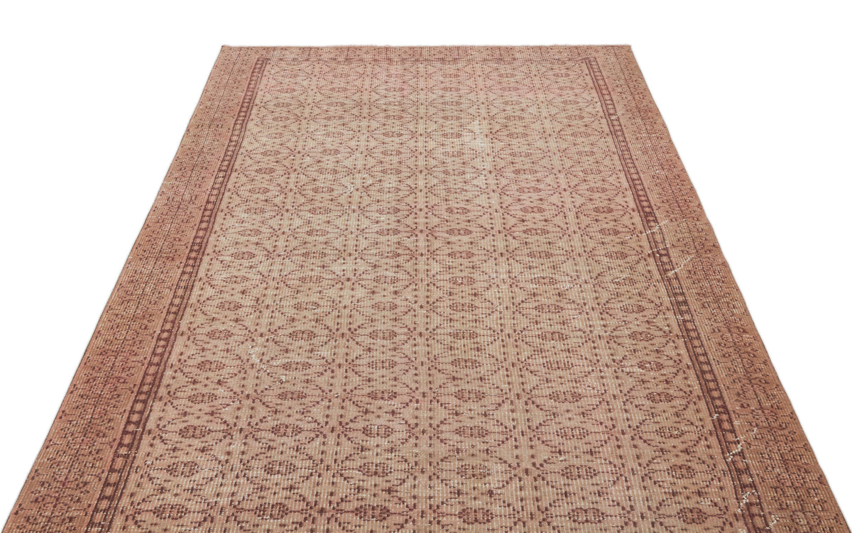 Terracotta and beige vintage-style rug with a repeating geometric diamond pattern and a decorative border.