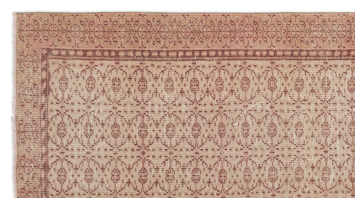 Terracotta and cream vintage-style rug with a repeating geometric lattice pattern and a decorative border.