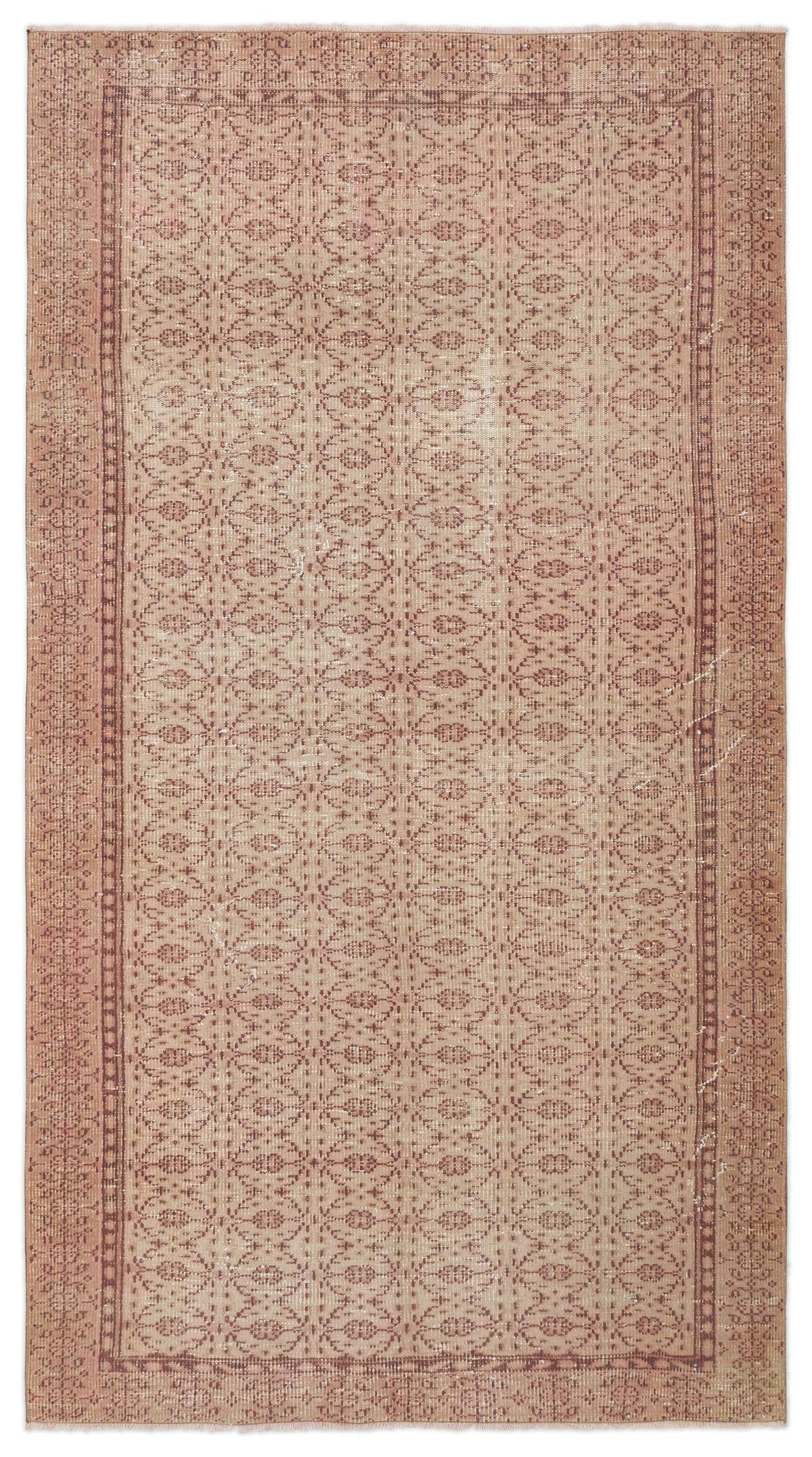 Dusty rose vintage-style rug with a repeating geometric lattice pattern and a decorative border.