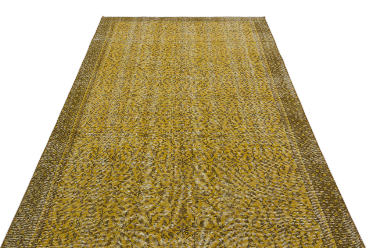 Mustard yellow and brown vintage-style rug with an intricate floral medallion pattern and a wide decorative border.