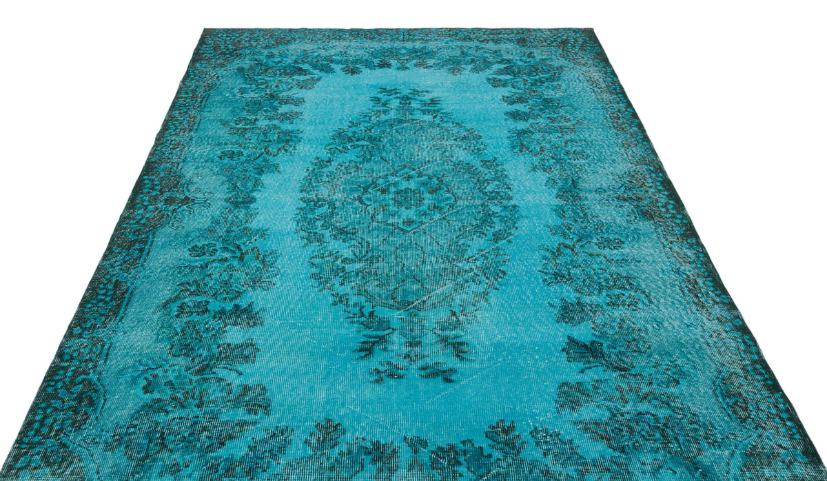 Turquoise and dark teal distressed rug with a traditional central medallion and floral border on a white background.