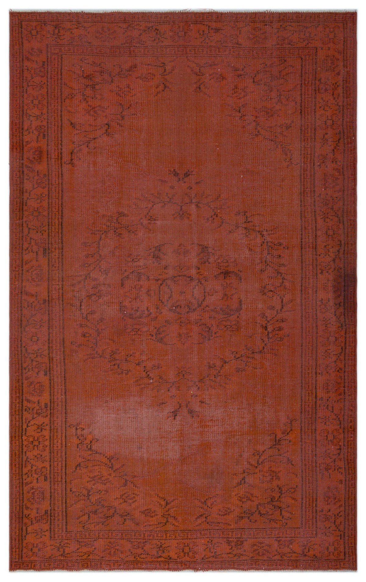 Rust-colored vintage rug with a dark, faded central floral medallion and a decorative border.
