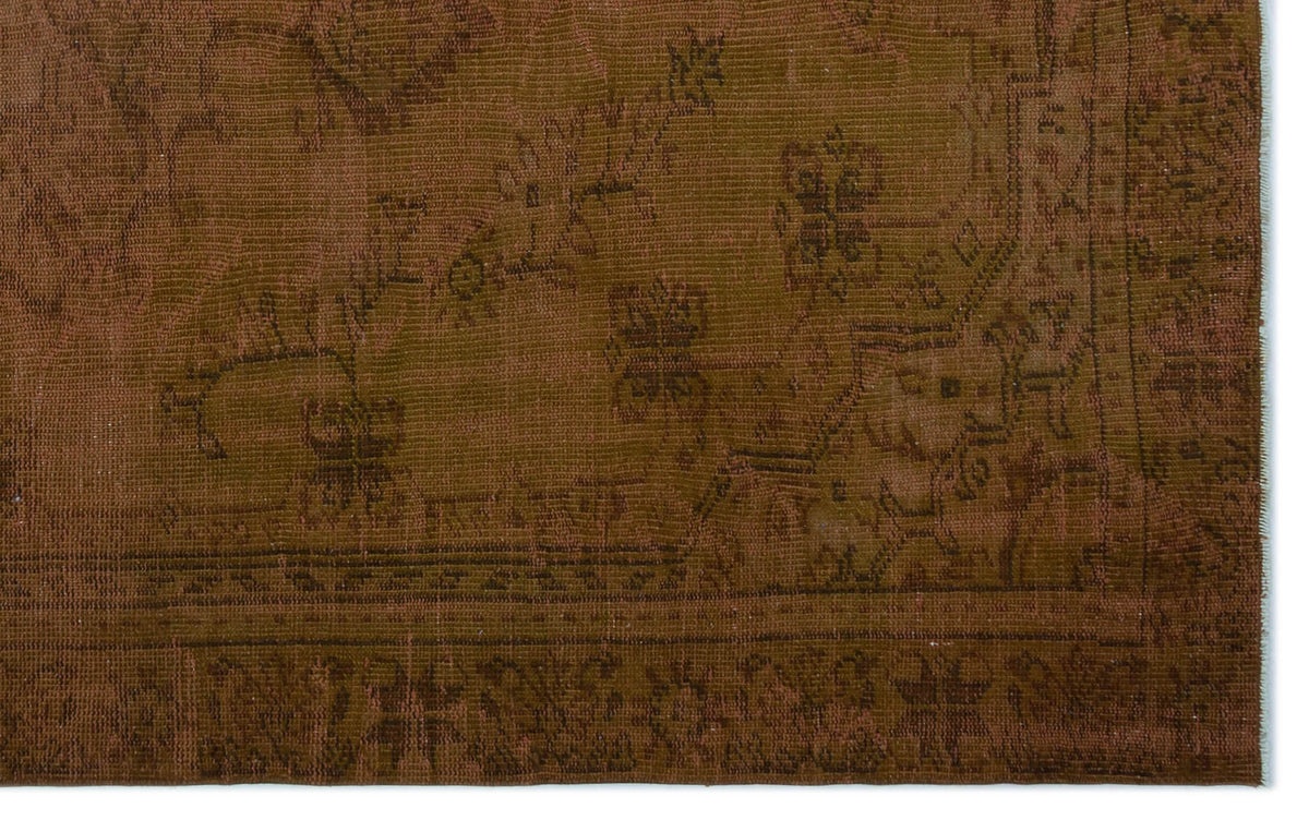 Monochromatic brown rug with a faded, traditional floral medallion pattern and a detailed border.