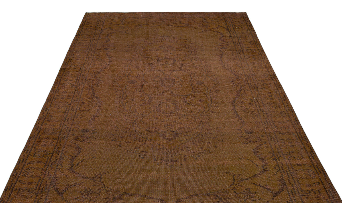 Dark brown vintage-style rug with a faint, tonal medallion pattern and a decorative border.