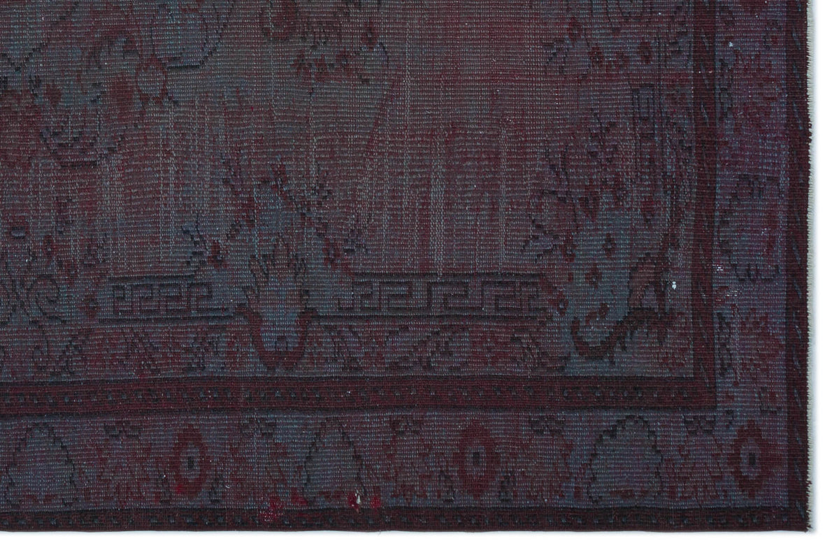 Deep burgundy and charcoal grey rug with a distressed traditional floral medallion and Greek key border pattern.