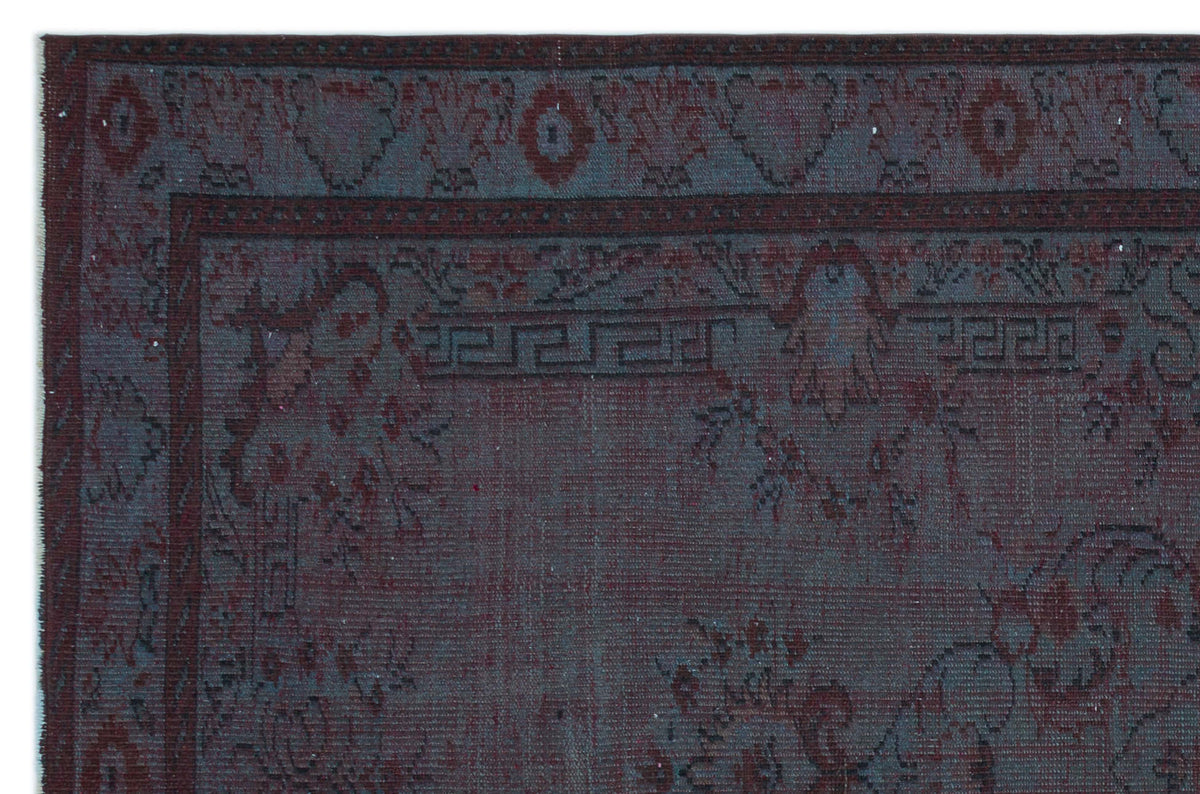 Dark charcoal and deep red traditional rug with a Greek key border and ornate floral motifs.